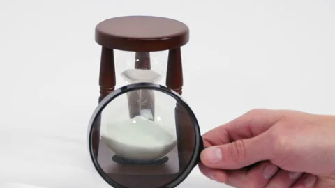 Looking at sand watch through magnifying glass Stock Footage 151923824