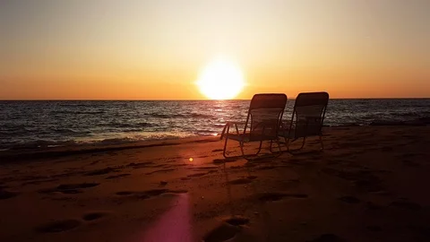Looking to the sea two empty chairs on sandy beach at sunset, Ionian coast Stock Footage 117768018