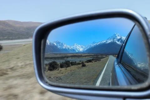 Looking in the side mirror of a car leaving the mountains behind. Fotos Stock