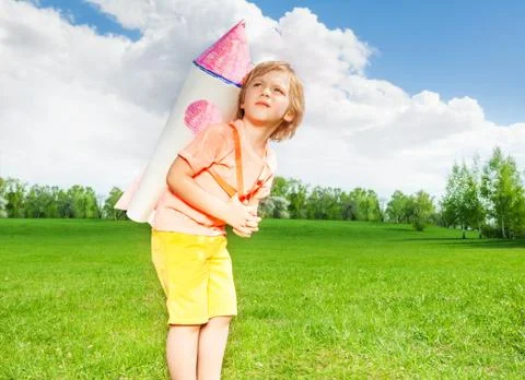 Looking small boy wears rocket toy on shoulders Stock Photos