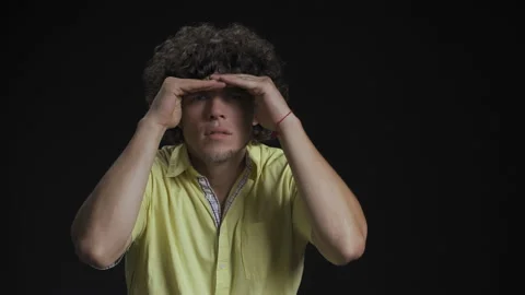 Looking for something young guy with long curly hair use hands to cover from Stock Footage 143617809