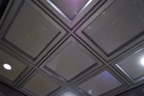 Looking Up at Square Recessed Panel Ceiling with Downlights in Jakarta Apartment Foto stock