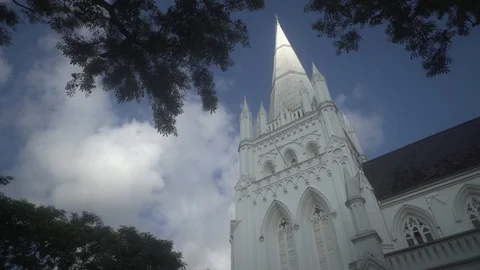 Looking up at St. Andrews Spire as clouds wisp by Singapore  Stock Footage 115780560