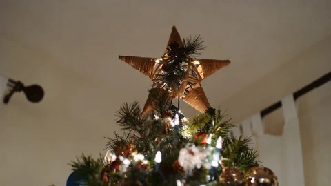 Looking up at the Star on top of the Christmas Tree in a low angle wraparound 8K Stock Footage 123482054