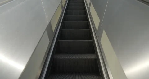 Looking straight ahead while riding an escalator upwards Stock Footage 276449123