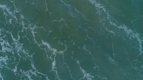 Looking straight down at turquoise water and sand lifted up from the sea floo Stock Footage 103470424