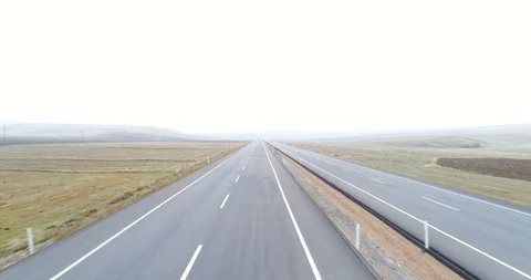 Looking straight at traffic on a county highway though foggy clouds. 4K Aerial Stock Footage 99725335