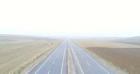 Looking straight at traffic on a county highway though foggy clouds. 4K Aerial Stock Footage 99725400