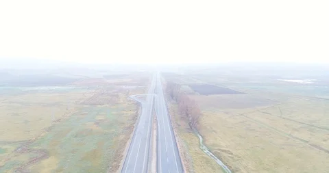 Looking straight at traffic on a county highway though foggy clouds. 4K Aerial Stock Footage 99725429