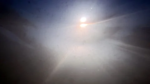 Looking Up at the Sun from Beneath the Water Surface with Floating Particles Stock Footage 340781195