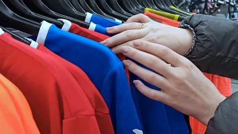 Looking for t-shirts on a hanger in a store Stock Footage 124401012