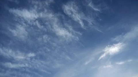 Looking up at thin cirrus clouds drifting across a blue summer sky Stock Footage 311128575