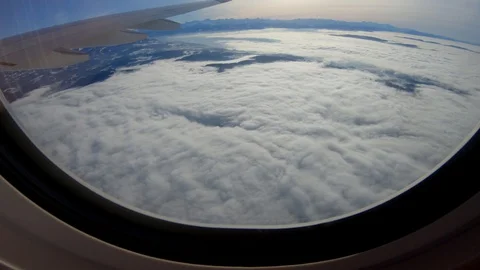 Looking Through Aircraft Plane Window Overlooking Clouds Sky in Flight Stock Footage 103587229