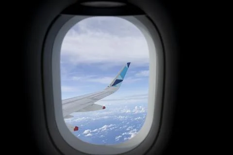 Looking through aircraft window during flight on the wing with a nice blue sky Stock Photos