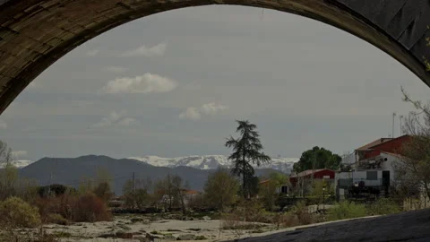 Looking through an ancient stone bridge arch at the dry riverbed Stock Footage 335461815