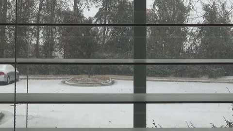 Looking through the blinds of a window at a snowstorm Stock Footage 84041377