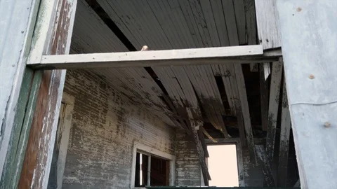 Looking through a broken window inside the work floor of an abandoned Stock Footage 129327331