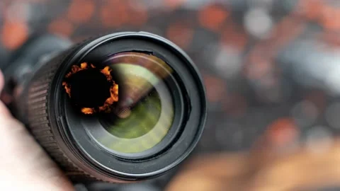 Looking through a camera lens while fire burns in the background Stock Footage 342831696