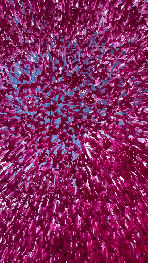 Looking up through a canopy of thousands of pink ribbons fluttering in the wind Stock Footage 314999114