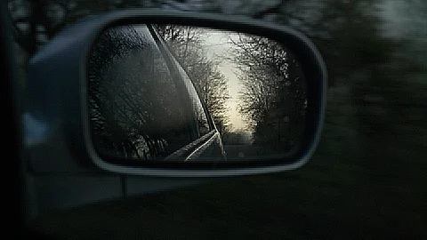 Looking through car mirror at sunrise - slow motion Stock Footage 89433335