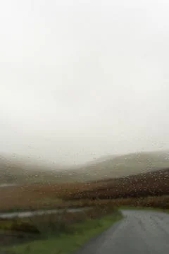 Looking through a car window blurred by raindrops. Stock Photos