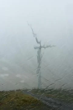 Looking through a car window blurred by raindrops, at a wind turbine Stock Photos