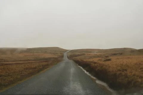 Looking through a car windscreen out onto a mountain road Stock Photos