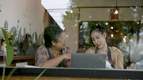 Looking through the coffee shop window, the woman who owns the bakery sits .. Stock Footage 252370259