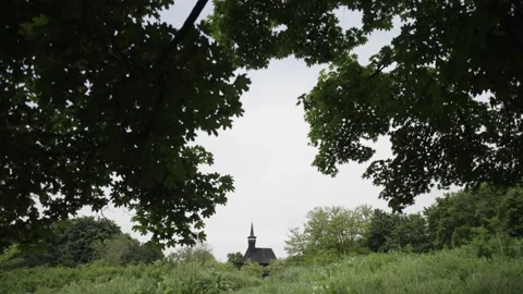 Looking Through Green Leaves at an Old Church in the Field Stock Footage 300489877