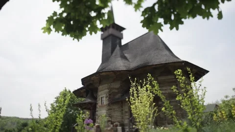 Looking Through Green Leaves at an Old Romanian Wooden Orthodox Church Video stock 300491015