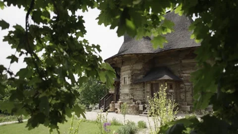 Looking Through Green Leaves at an Old Romanian Wooden Orthodox Church 스톡 동영상 300491094