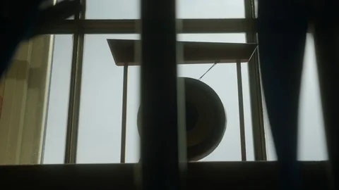 Looking through the iron bars at a small illuminated gong at the window Video stock 127475070