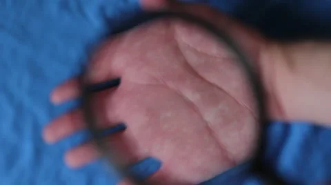 Looking through the magnifying lens on hands Vídeo Stock 66753579