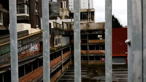 Looking through metal bars at an abandoned building Video stock 171799309