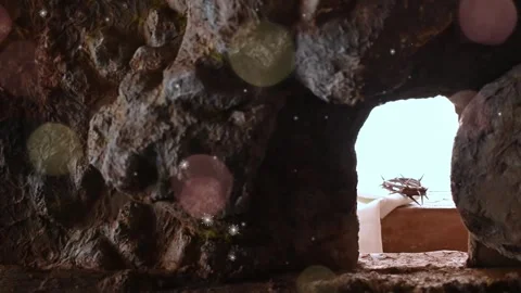 Looking through a natural stone cave opening towards a bright sky in a rugged Stock Footage 338440043