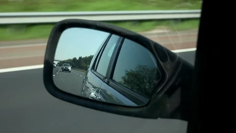Looking through passenger side mirror of a car with transport behind 4K Stock Footage 90119714