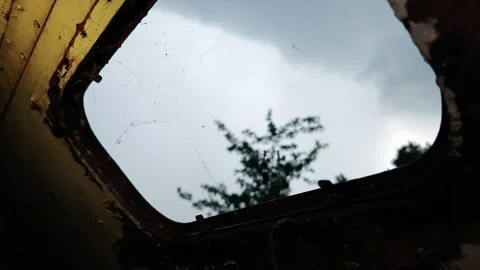 Looking Up Through Roof Window of Abandoned Trailer at Heavy Rain Stock Footage 339590048