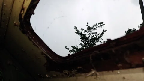Looking Up Through Roof Window of Abandoned Trailer at Heavy Rain Stock Footage 339590089