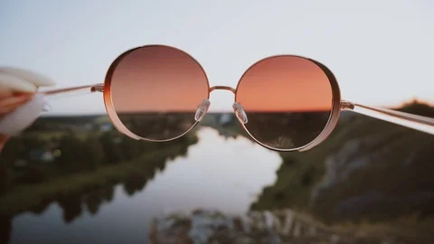 Looking through the sunglasses on the sunset at river in countryside. Stock Footage 122559899