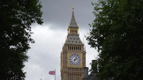 Looking through trees at Big Ben (The Elizabeth Tower) on cloudy moody day Stock Footage 281232544