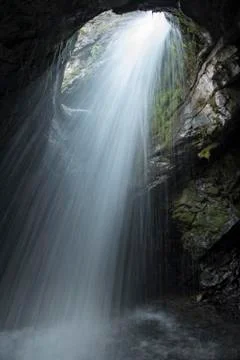 Looking up through unique waterfall inside a cave Stock Photos