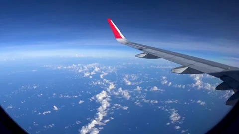 Looking through window aircraft during flight with a nice blue sky with clouds Video stock 133136456
