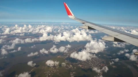 Looking through window aircraft during flight with a nice blue sky with clouds Video stock 133574035