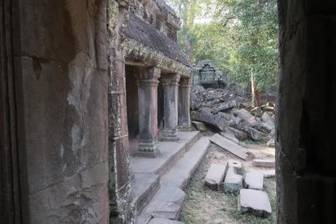 Looking through a window on ancient, crumbling stone temple ruins of angkor wat Stock Photos
