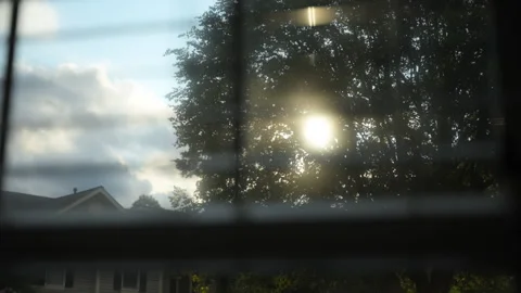Looking at through window closed by blinds and sun rays. Close up view Stockbeeldmateriaal 296086893