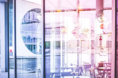 Looking through window of empty restaurant on river and modern architecture Stock Photos