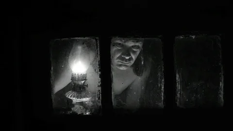 Looking through a window in the light of a kerosene lamp black and white Stock Footage 112921320