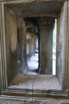 Looking through a window at stone pillar in famous histroical angkor wat ruins Stock Photos