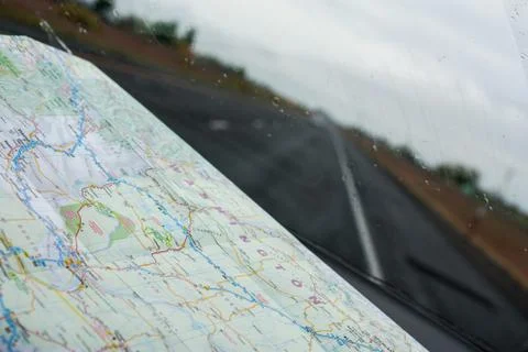 Looking through a windshield with a road map on the dashboard Stock Photos