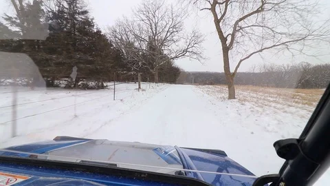 Looking through the windshield of a side-by-side ATV on a snowy road. 스톡 동영상 119972967